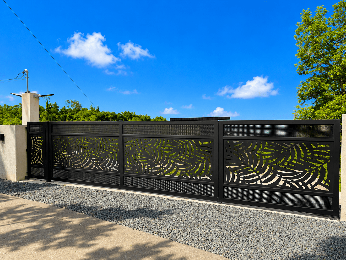 Black driveway gate with waterjet-cut palm frond pattern