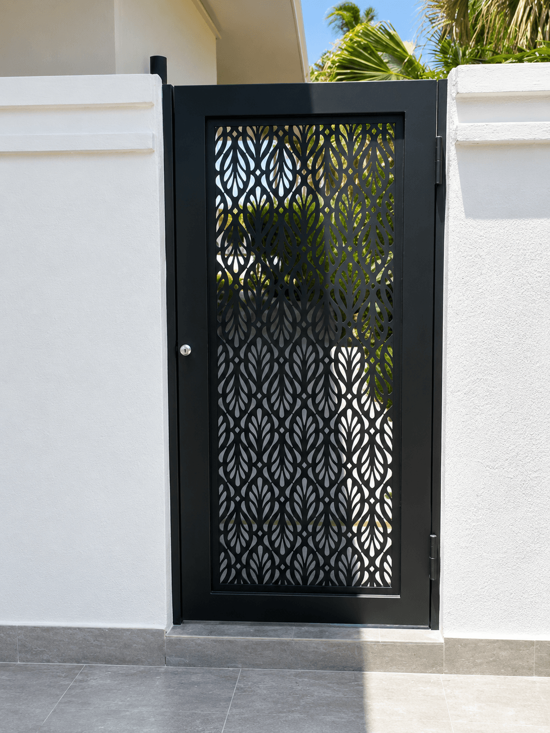 Black pedestrian gate with waterjet-cut damask leaf pattern