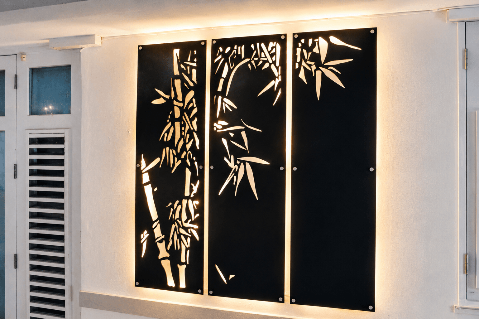 Backlit bamboo triptych in interior hallway