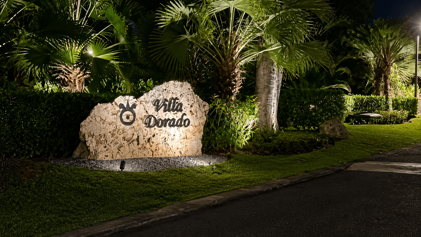Villa Dorado illuminated stone signage at night