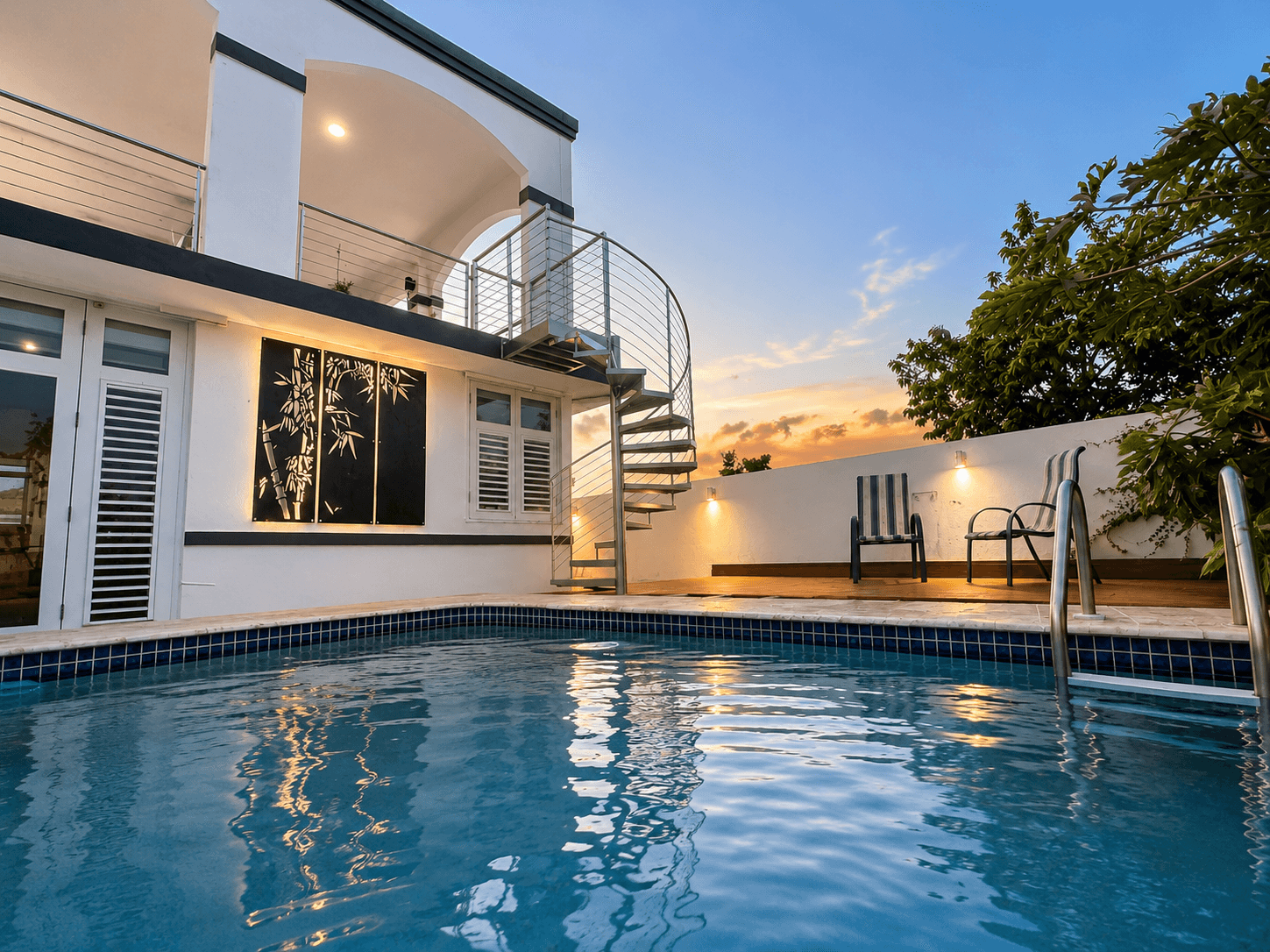 Residential pool area with spiral staircase and bamboo panel
