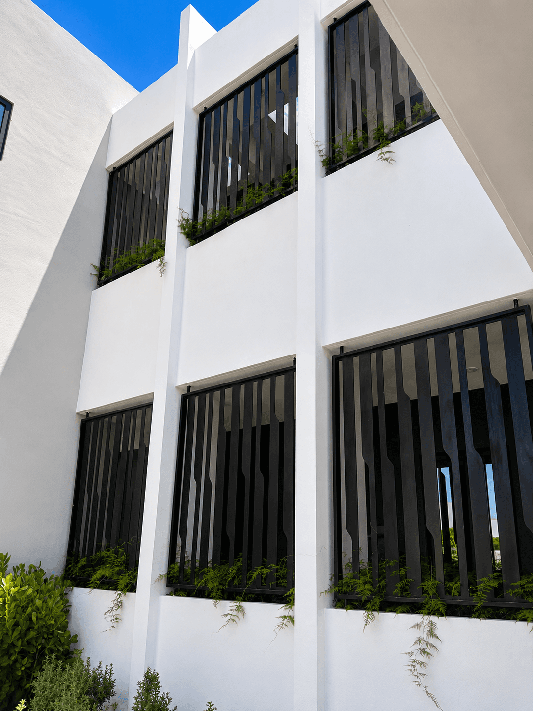 Building facade with vertical bar window screens