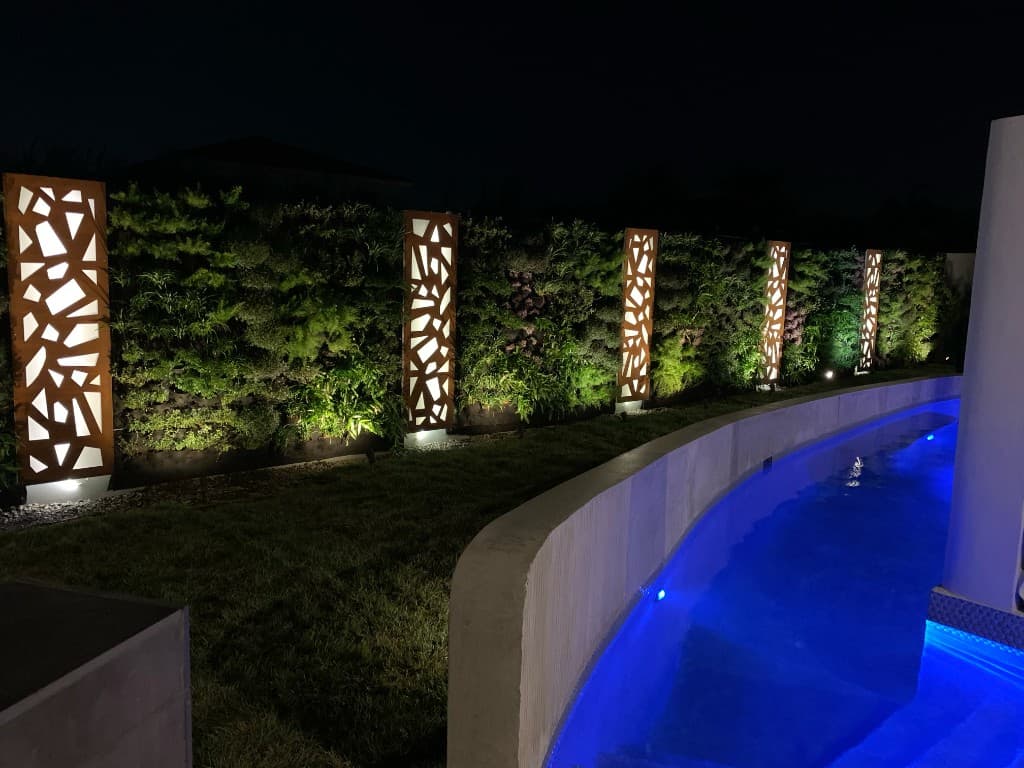 Backlit waterjet panels in living wall at poolside